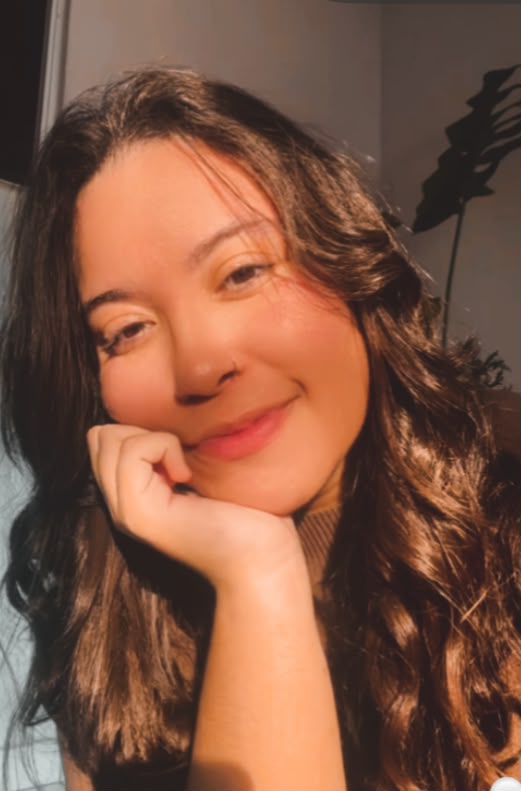 Gabi sorrindo, com o queixo apoiado na mão