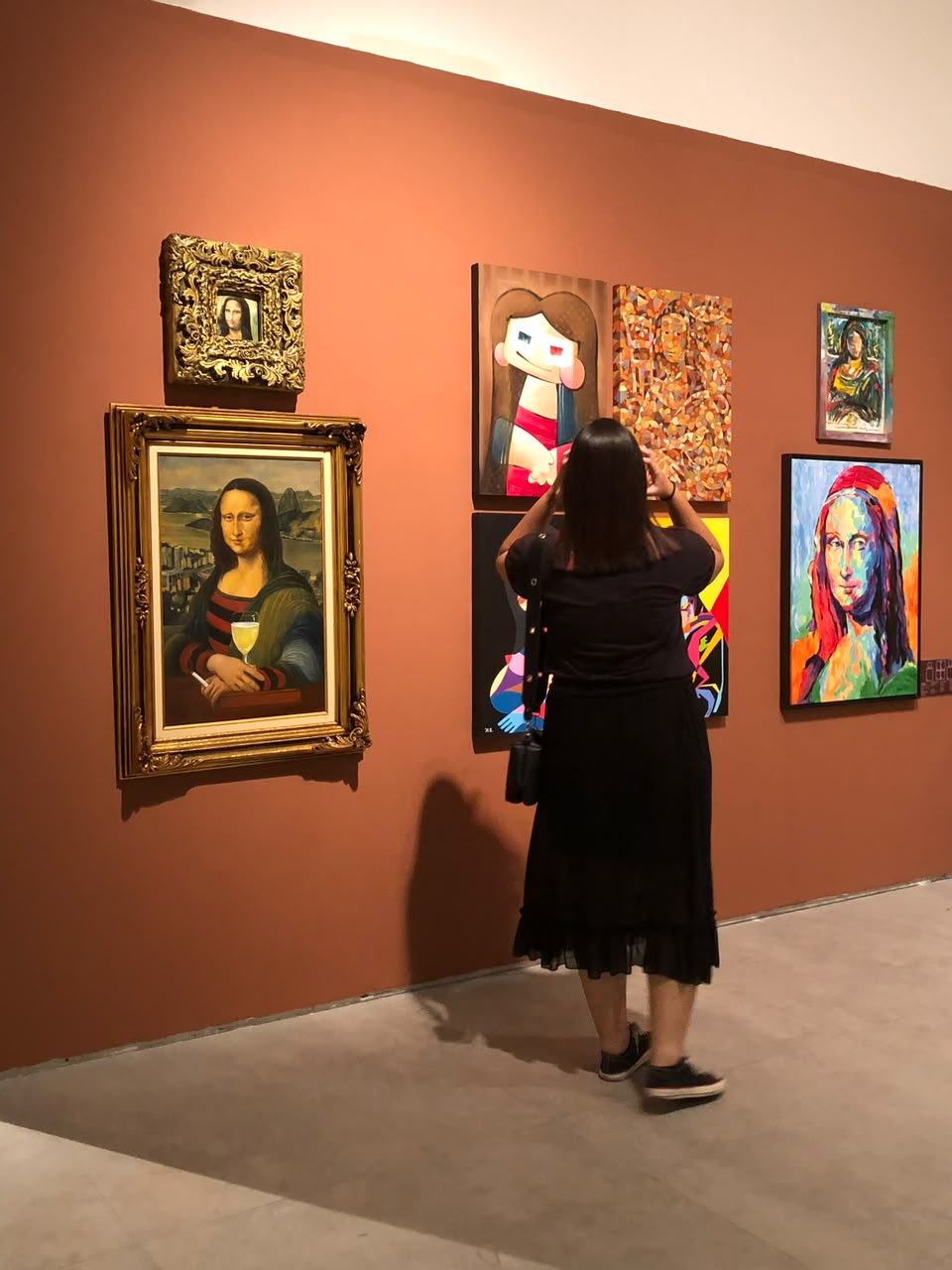 Gabi fotografando quadros em uma exposição