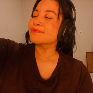 Gabi com fones de ouvido, de olhos fechados